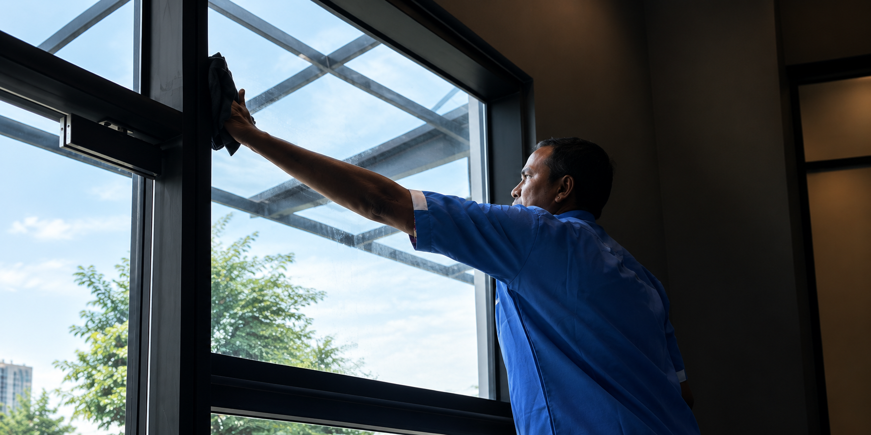 CSC Services cleaner wiping a window